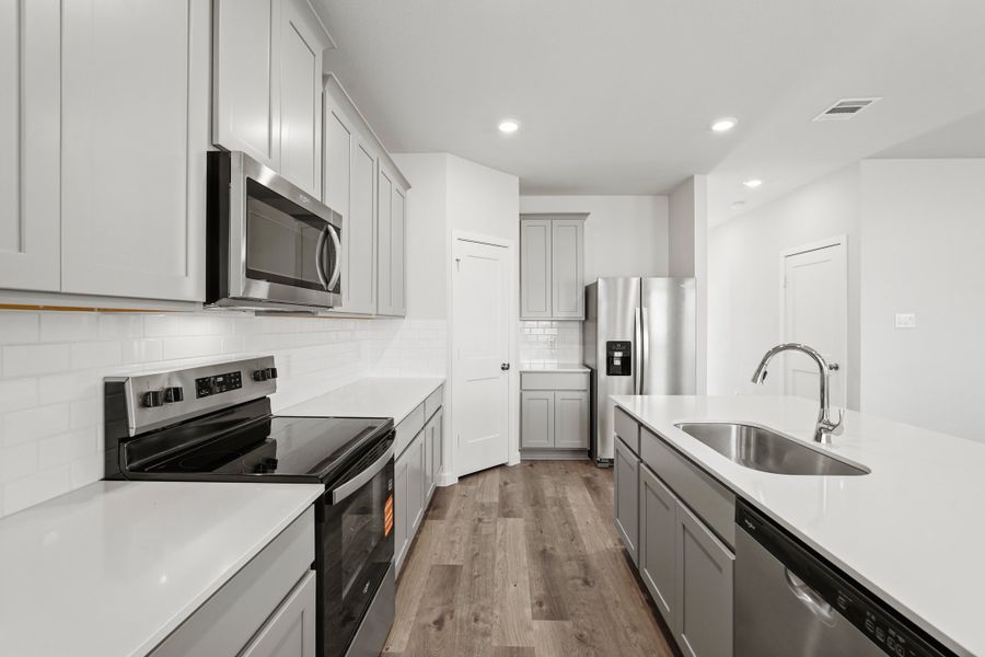 A kitchen with white cabinets.