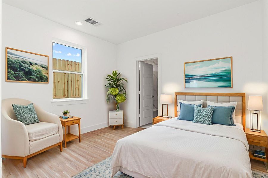This inviting first-floor bedroom features soft recessed lighting and a private en-suite bath, offering comfort and convenience for guests or multi-generational living. *Virtually stages*