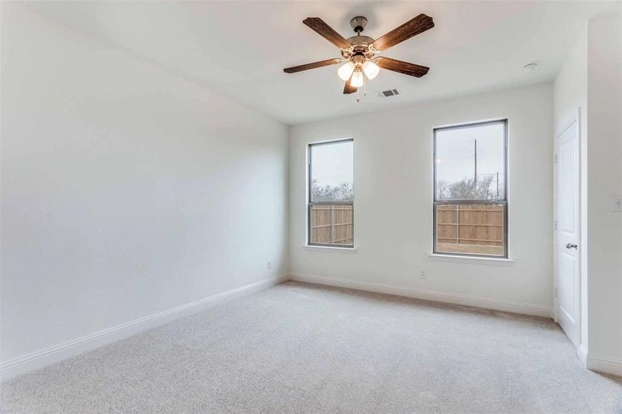 Spare room with light colored carpet, ceiling fan, and baseboards