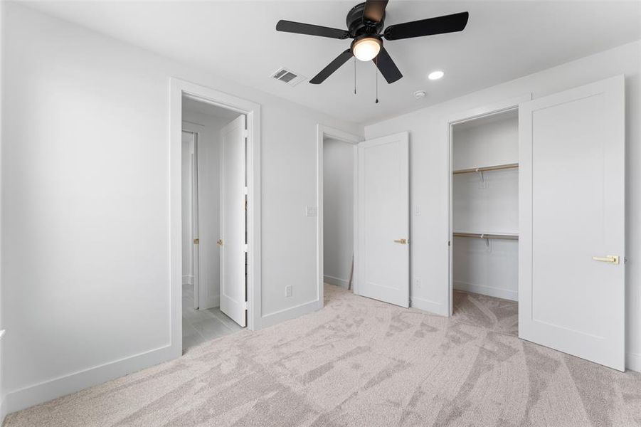 Unfurnished bedroom with light carpet, ceiling fan, and recessed lighting
