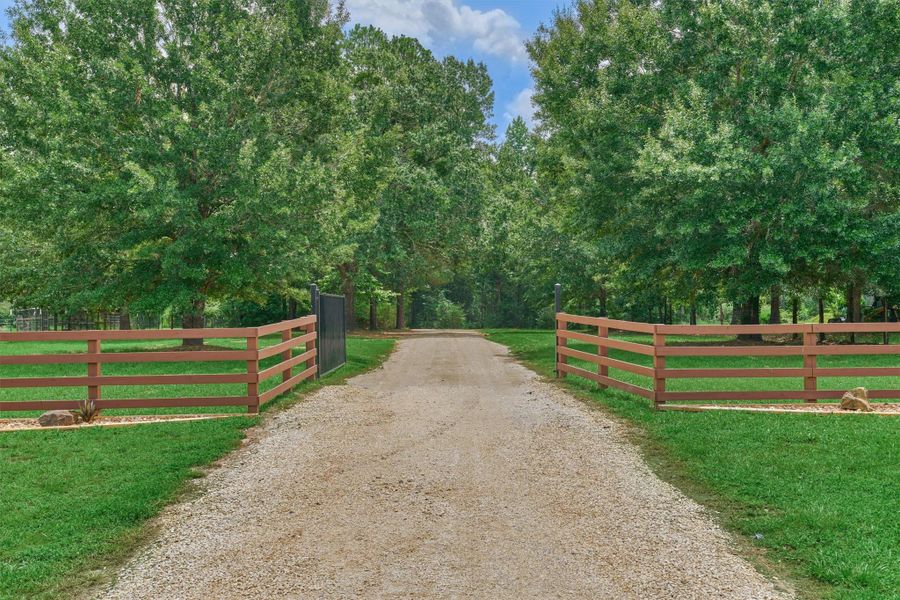 Gated private entry with long driveway and electric gate for added privacy and security