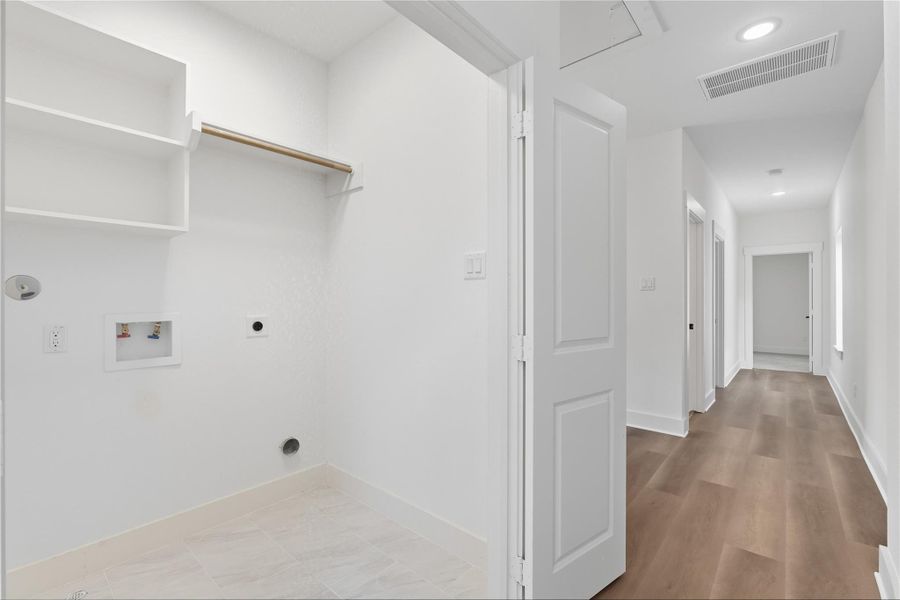 This dedicated laundry room makes everyday tasks easier, with built-in shelving for organization and space for full-size washer and dryer units. Conveniently located, it’s designed to keep the home running smoothly while offering plenty of storage to keep your things tidy!