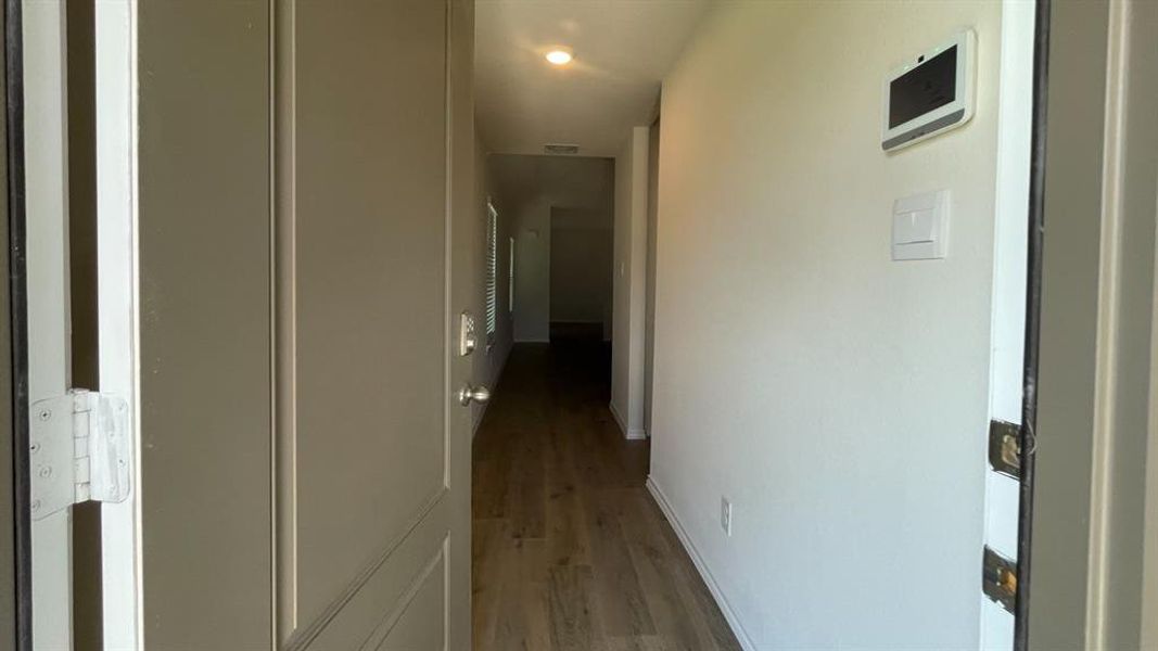 Entryway featuring wood-finish flooring extending through the hall, recessed lighting, and a neutral wall palette Entryway featuring wood-finish flooring extending through the hall, recessed lighting, and a neutral wall palette