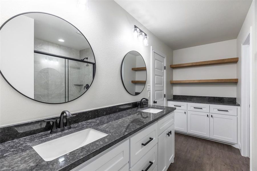Dual vanity with dark stone-finish countertop, undermount sinks, and matte black fixtures