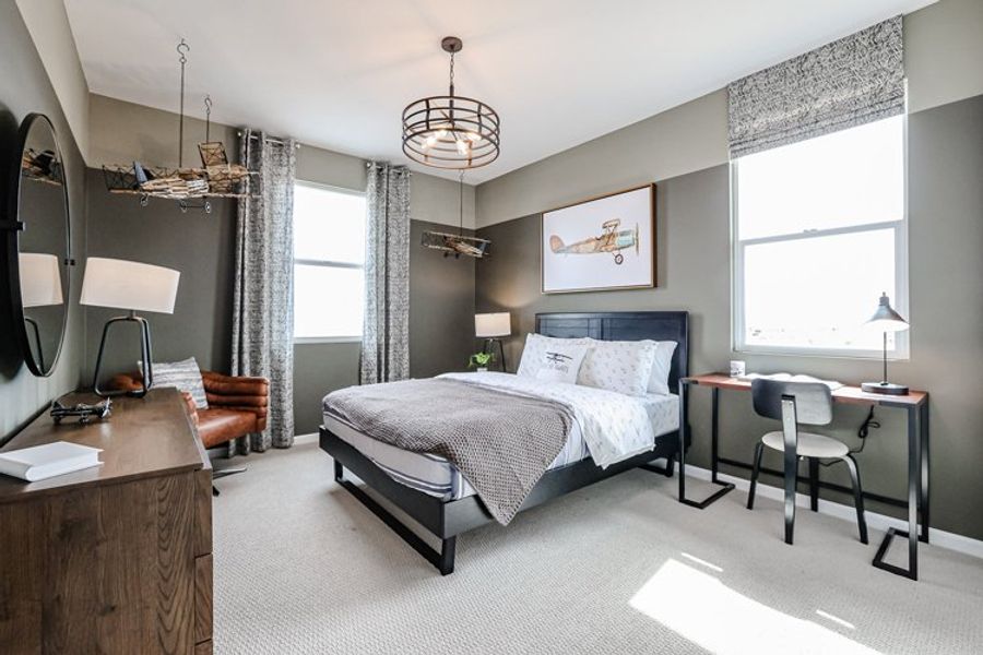 A bedroom with a bed desk and a mirror. A bedroom with a bed desk and a mirror.
