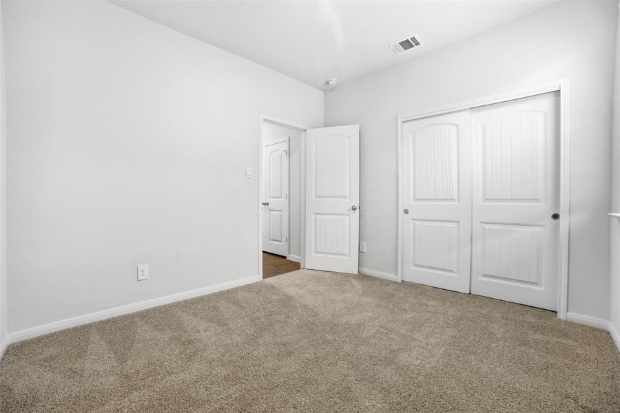 Unfurnished bedroom with carpet and a closet Unfurnished bedroom with carpet and a closet