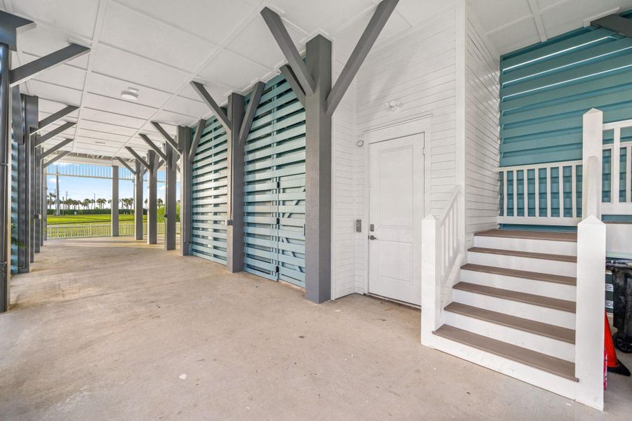 Large garage with elevator access, storage, and outdoor shower