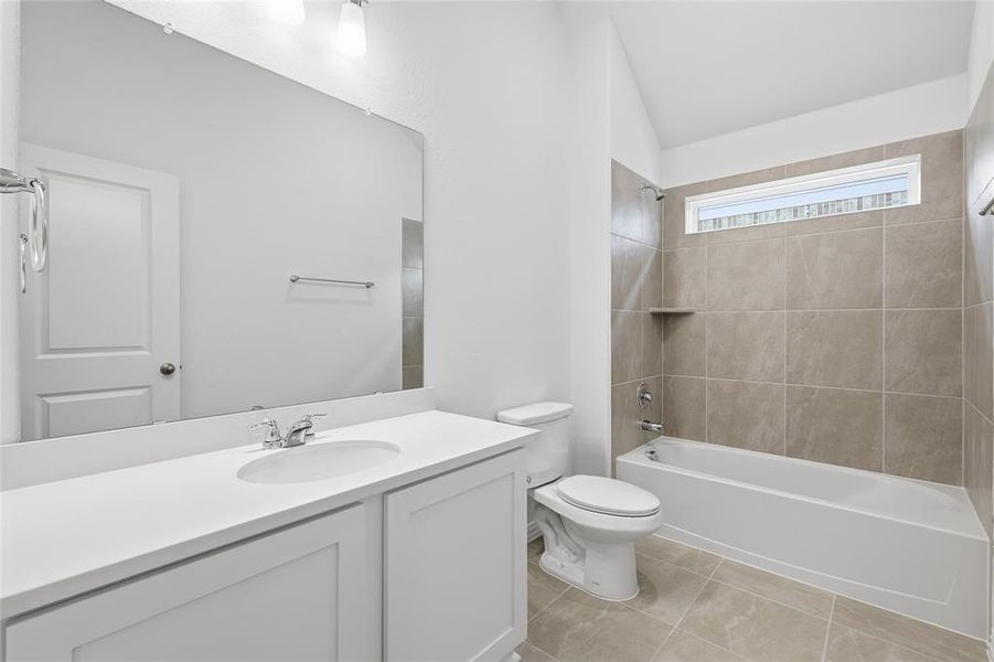 Bathroom featuring a wide vanity with an integrated sink, polished chrome faucet, and a large wall-mounted mirror