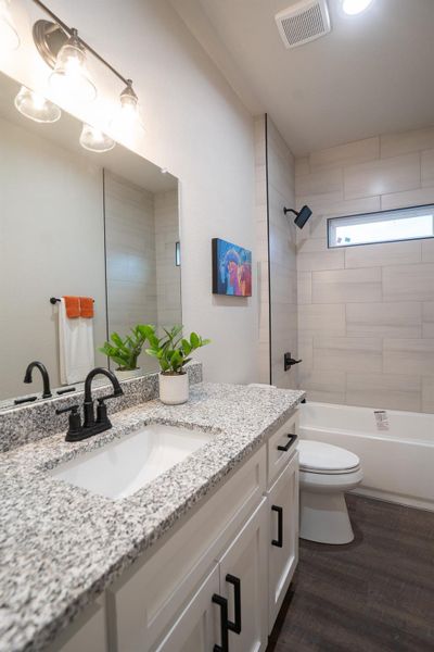 Bathroom with vanity, toilet, wood finished floors, and shower / tub combination Bathroom with vanity, toilet, wood finished floors, and shower / tub combination