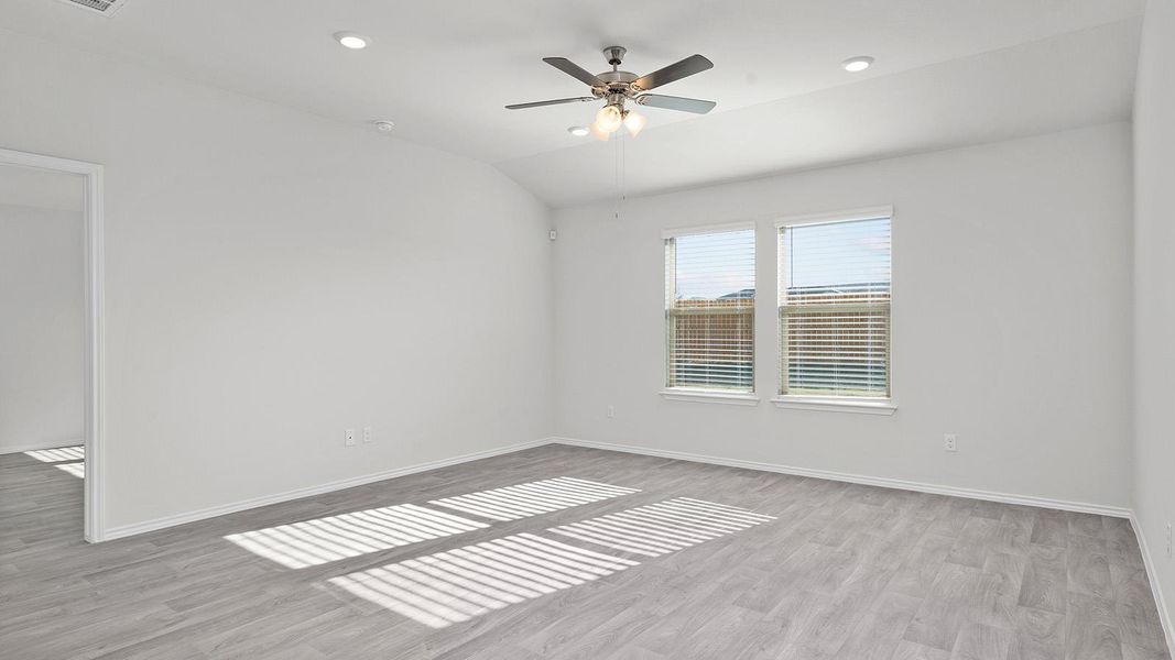 Empty room with lofted ceiling, light wood finished floors, ceiling fan, and recessed lighting