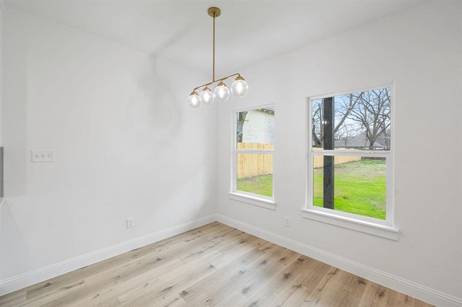 Unfurnished dining area featuring wood finished floors and baseboards