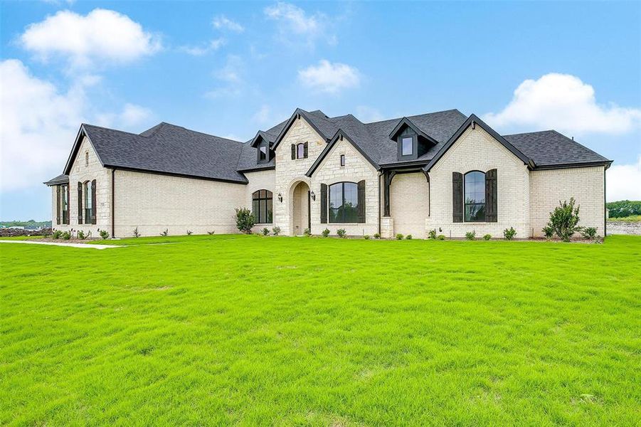 French country home featuring a front yard