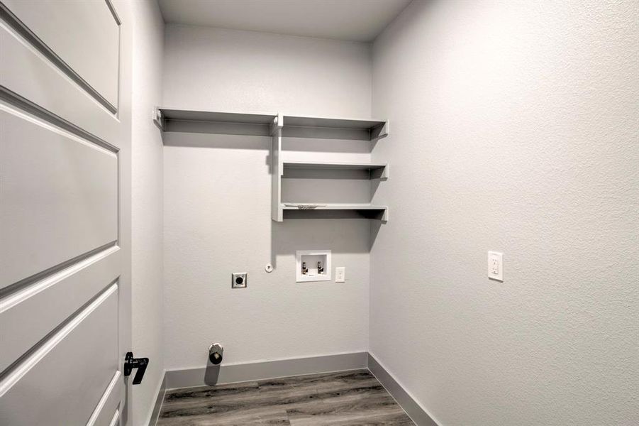 Laundry room with light wood-type flooring, hookup for an electric dryer, washer hookup, and hookup for a gas dryer Laundry room with light wood-type flooring, hookup for an electric dryer, washer hookup, and hookup for a gas dryer