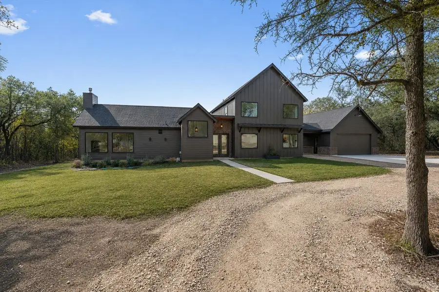 Modern dwelling featuring a sleek dark exterior and expansive windows, nestled amidst natural landscaping. Modern dwelling featuring a sleek dark exterior and expansive windows, nestled amidst natural landscaping.