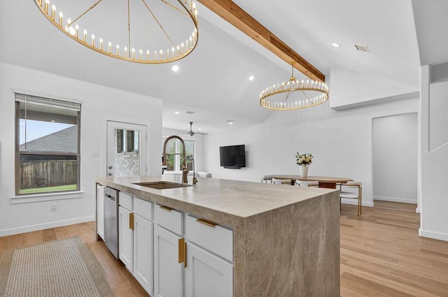 Kitchen island with waterfall countertop, undermount sink, and integrated dishwasher
