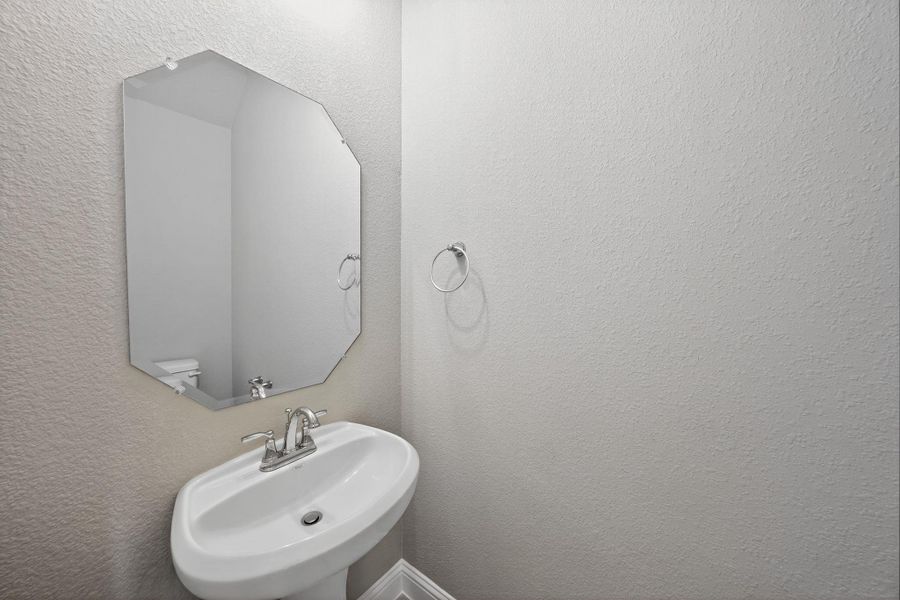 Bathroom with a sink and a textured wall Bathroom with a sink and a textured wall