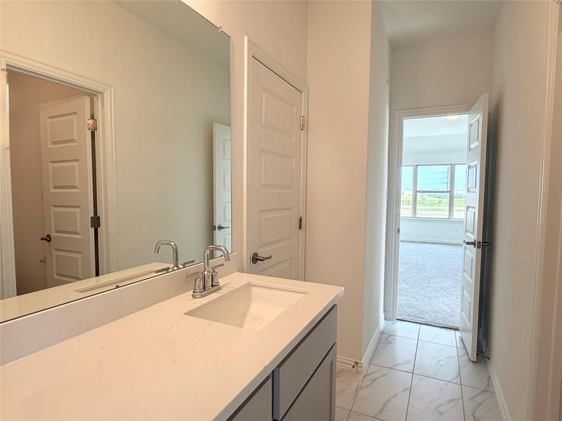 Bathroom featuring marble look tiles and vanity Bathroom featuring marble look tiles and vanity