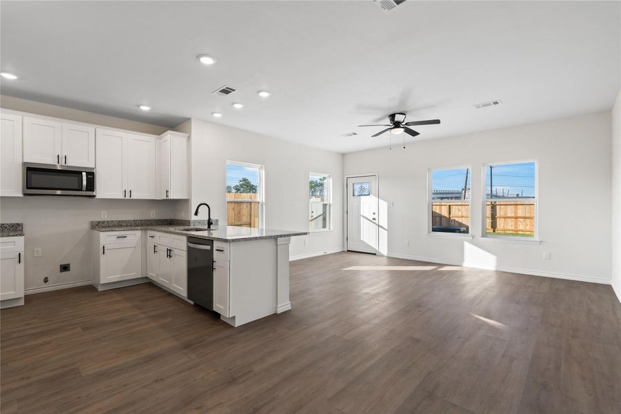 This kitchen opens effortlessly to the living and dining rooms, enhancing the home’s bright, open flow and modern farmhouse feel.