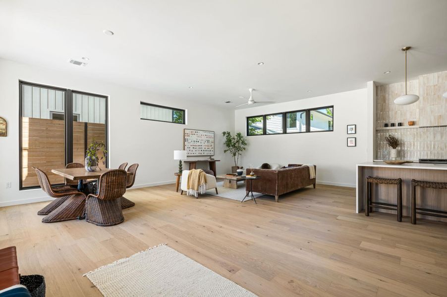 Smooth wood floors and tall windows define this expansive open-concept living area.