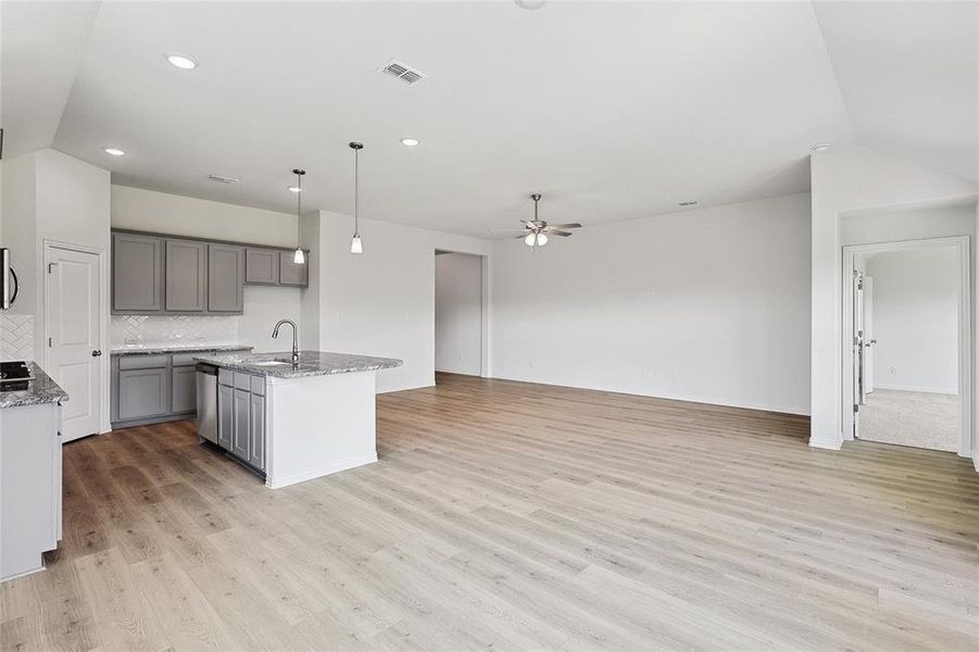 Kitchen featuring an island with sink, pendant lighting, and light hardwood / wood-style floors