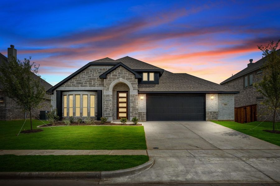 Single-story home with stone exterior, arched entry, two-car garage, and green front lawn at dusk