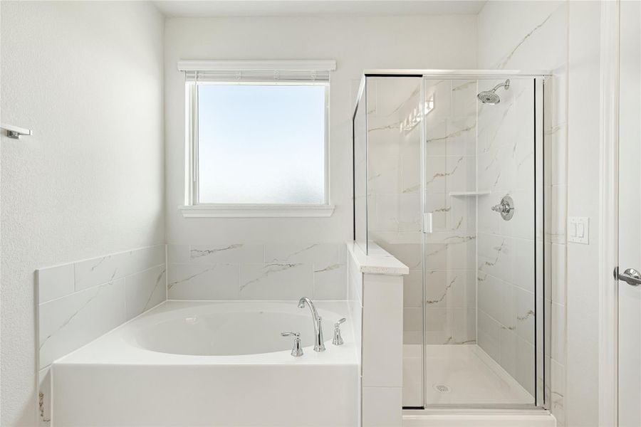 Bathroom with soaking tub, glass-enclosed shower, and white marble tile walls