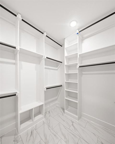 Walk in closet featuring light marble finish floors