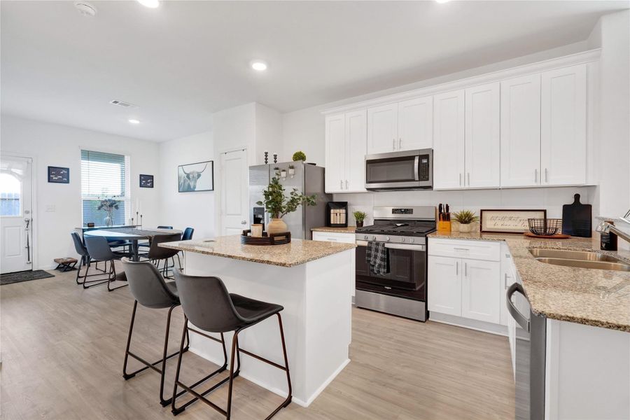 Fall in love with a modern chef’s kitchen featuring stainless-steel appliances, sleek cabinetry, ample counter space, and a large breakfast bar, creating a perfect balance of beauty and functionality.