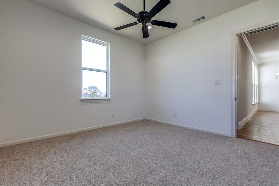 Empty room with ceiling fan, light carpet, and crown molding