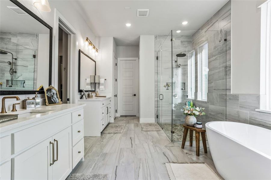 Enjoy a daily trip to your own spa-like bathroom complete with a stand alone tub and a frameless glass oversized shower, separate vanities, upgraded tile surrounding the shower and tub walls