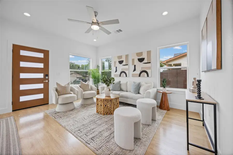 A luminous living room, anchored by a stylish area rug, invites comfortable gatherings with ample seating and a warm, wooden entry door. A luminous living room, anchored by a stylish area rug, invites comfortable gatherings with ample seating and a warm, wooden entry door.