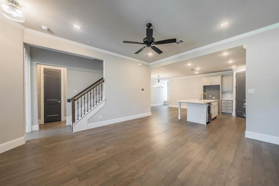 Open-concept living area featuring wood-finish flooring, recessed lighting, and a modern ceiling fan