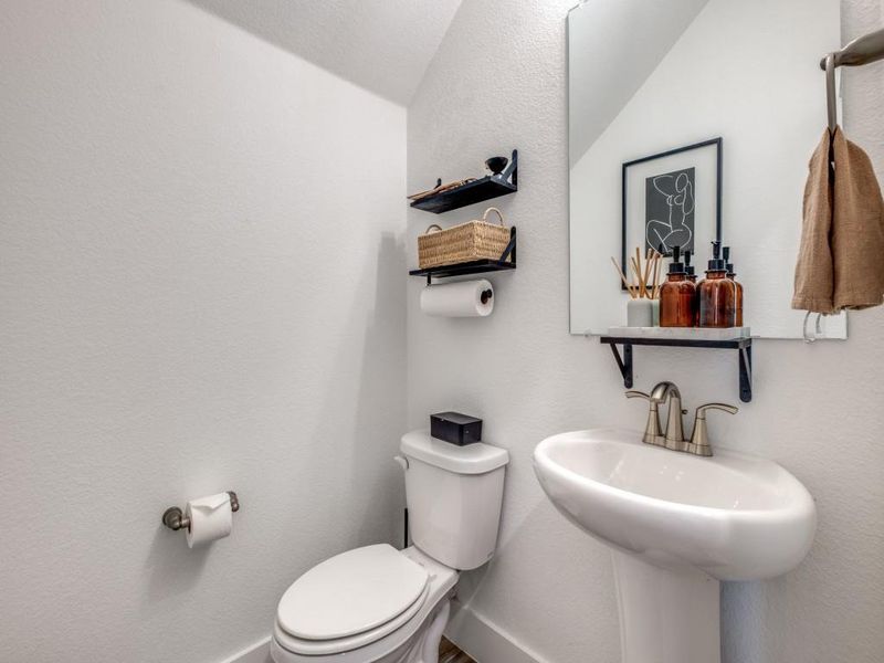 Half bathroom featuring toilet and baseboards