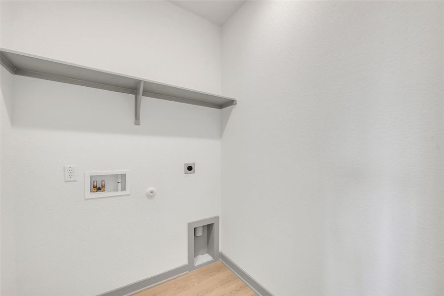 Laundry area featuring gas dryer hookup, light wood finished floors, hookup for an electric dryer, and washer hookup