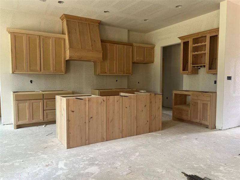 Kitchen with a center island and custom exhaust hood