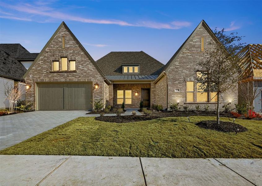 View of front of home featuring a garage and a lawn