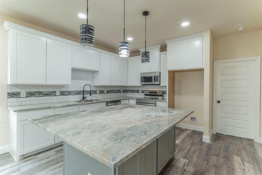 Kitchen featuring a center island, stainless steel appliances, and white cabinets