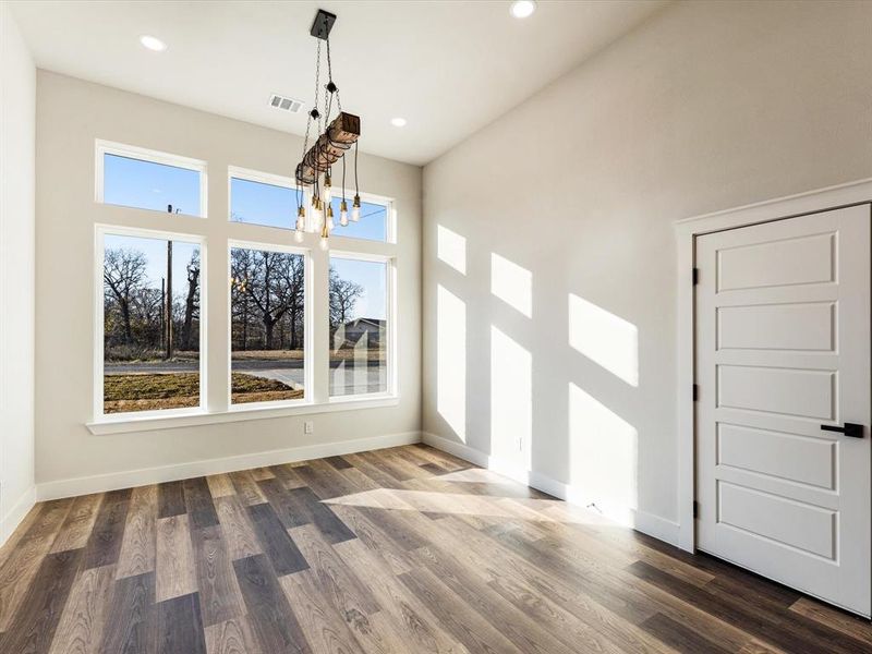 Unfurnished dining area with wood finished floors, a chandelier, and recessed lighting Unfurnished dining area with wood finished floors, a chandelier, and recessed lighting