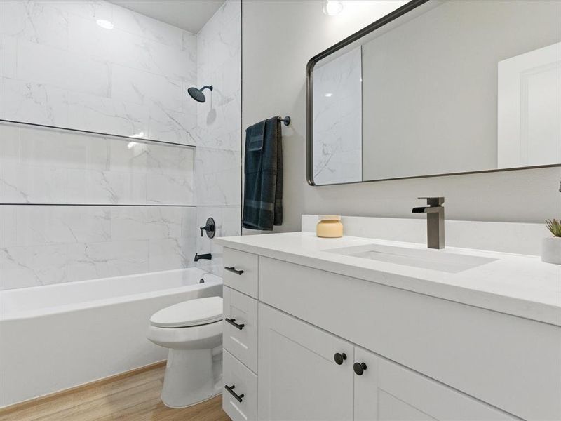 Bathroom with bathtub / shower combination, light wood-type flooring, and vanity Bathroom with bathtub / shower combination, light wood-type flooring, and vanity