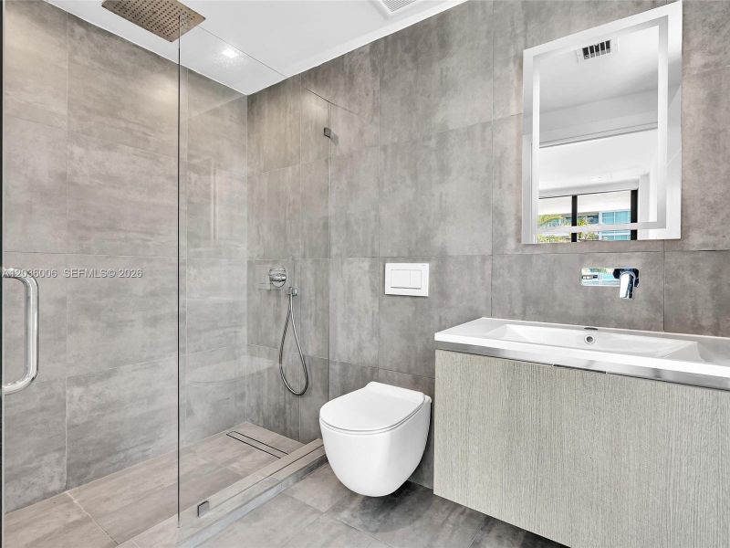 Bath with glass shower.