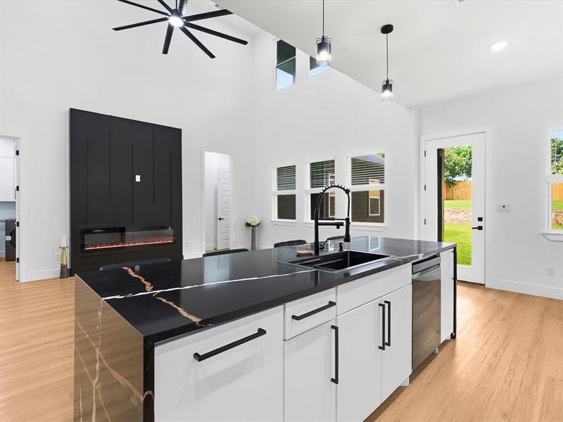 Kitchen island featuring a black countertop with distinctive veining, an undermount sink, and a black gooseneck faucet