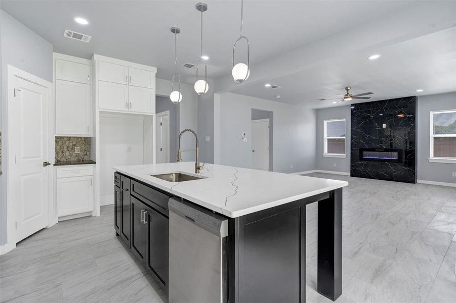 Kitchen with stainless steel dishwasher, a ceiling fan, light stone counters, white cabinets, and pendant lighting