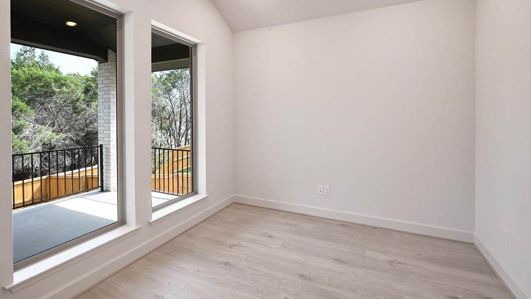 Unfurnished room featuring light wood-style flooring and vaulted ceiling