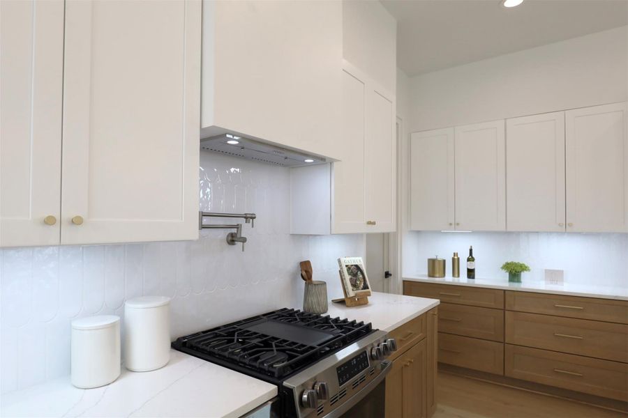 Uninterrupted backsplash is illuminated by the under cabinetry lights, paired with outlets for an increase of kitchen cooking ease.