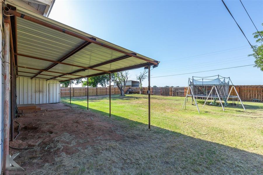 Fenced backyard with a playground