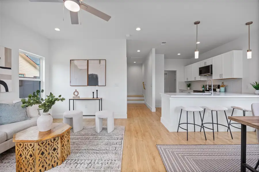 An open-concept layout unites the naturally illuminated living space with a modern, well-appointed kitchen. An open-concept layout unites the naturally illuminated living space with a modern, well-appointed kitchen.