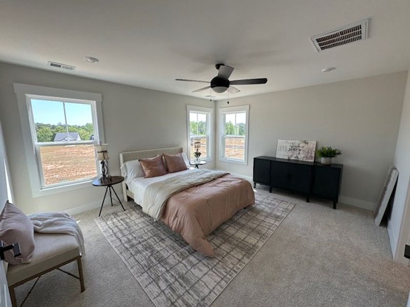 This spacious bedroom offers serene views and comf