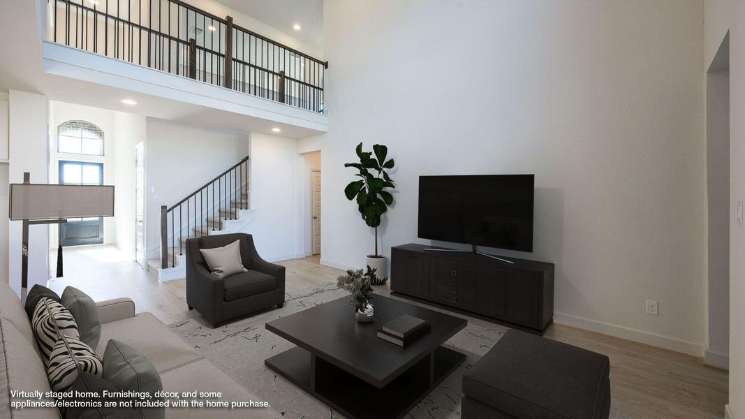 Living area with light wood-type flooring, a high ceiling, stairway, and recessed lighting Living area with light wood-type flooring, a high ceiling, stairway, and recessed lighting