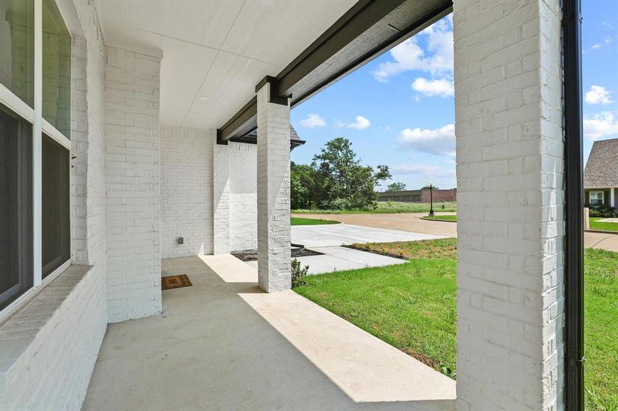 Covered porch with white painted brick columns and a contrasting dark soffit Covered porch with white painted brick columns and a contrasting dark soffit
