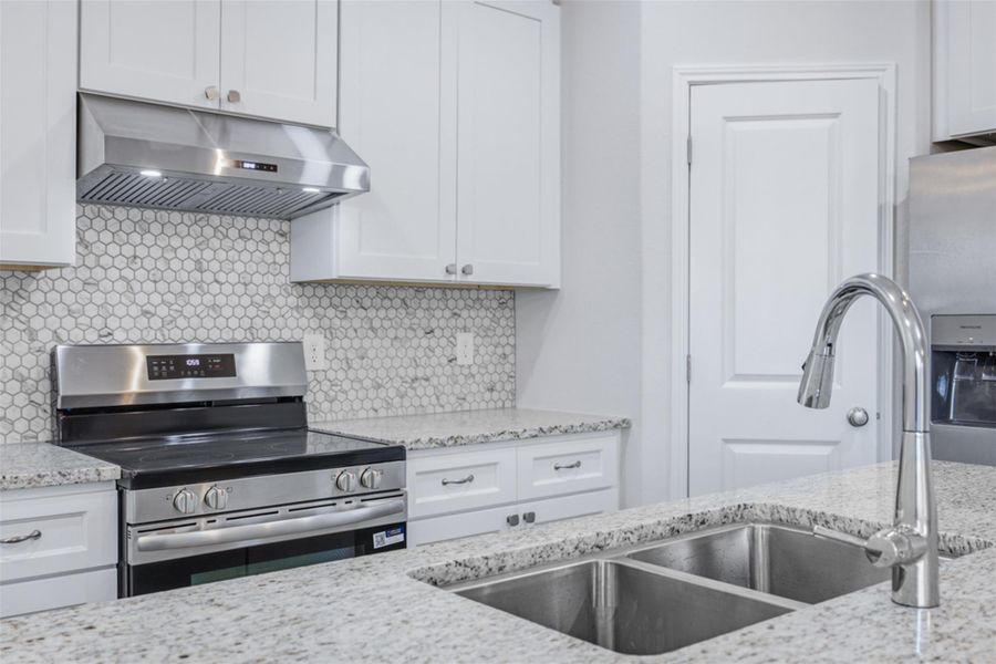 Culinary delights await in this bright kitchen with granite counters and stainless steel appliances.